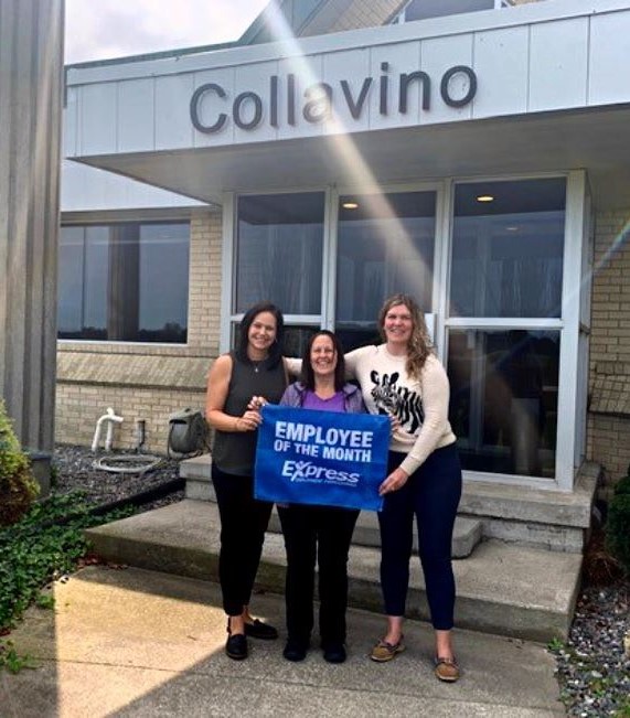 Associate Joanna Fenton stands with her two supervisors in front of the Collavino Group building, holding an Employee of the Month banner