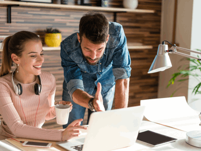 Coworker helping another with on her computer at the office
