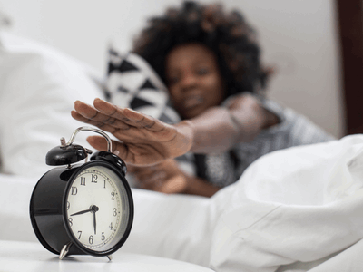 Women waking up in morning to time clock to get ready for work