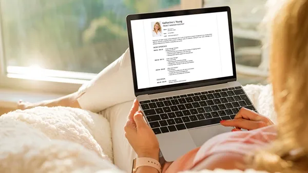 Person reviewing a resume on a laptop, highlighting job search efforts and career development.