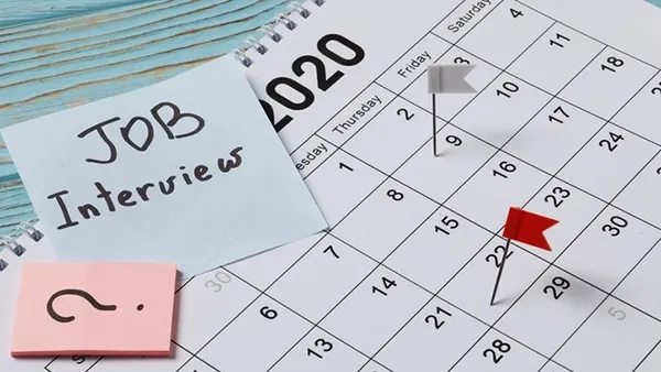 Professional workspace with notebooks, pens, and a calendar, symbolizing organized communication and the process of professionally rescheduling a job interview.