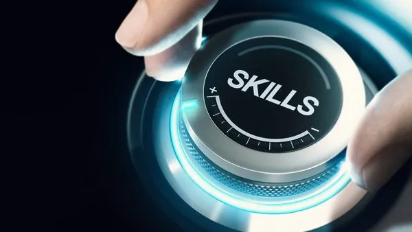 A hand adjusts a glowing, futuristic dial labeled “SKILLS,” symbolizing increasing or enhancing abilities.