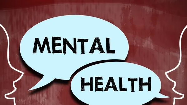 Photo illustration of two outlined human profiles facing each other on a red chalkboard background, with blue speech bubbles reading “MENTAL HEALTH.” A hand holding white chalk appears in the lower-left corner.