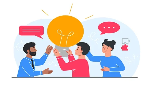 Illustration of three people—two appearing male and one appearing female—collaborating around a large glowing lightbulb icon, with speech bubbles and a puzzle piece symbol in the background. All wear casual long‑sleeve clothing in blue and red tones.