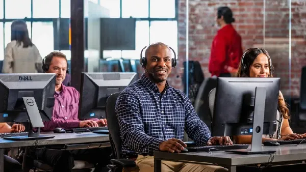 People at desks and computers with headsets on