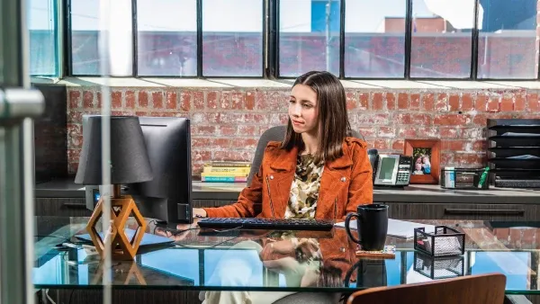 Woman sitting at a desk looking at a screen