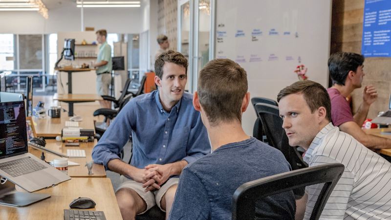 A group of coders at a tech start-up discussing a problem