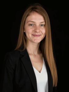 Professional photo of Brooke. She is wearing business professional clothes. She has light colored hair.