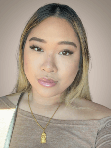 photo of a young woman in a tan top and blonde hair