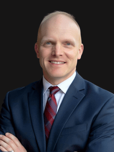 Professional photo of Adam. He is a middle aged man. He is dressed in business professional clothes. 
