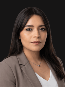 Professional photo of Andrea. She is a young woman with dark hair. She is dressed in business professional clothes. 