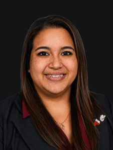 Professional photo of Angie. She is a young woman with dark hair. She is dressed in business professional clothes. 