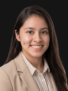 Professional photo of Aylin, a young woman with dark hair dressed in business professional clothes.