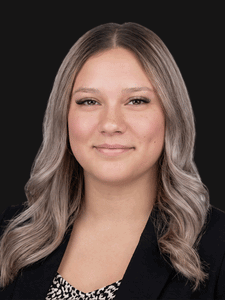 Professional photo of Denise, a young woman with blonde hair. She is dressed in business professional clothes.