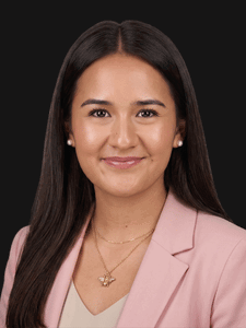Professional photo of Kimberly, a young woman with dark hair. She is dressed in business professional clothes.