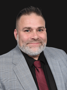 Professional photo of Roger, a middle aged man dressed in business professional clothes.