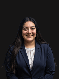 Professional photo of Rosa, a young woman with dark hair dressed in business professional clothes.