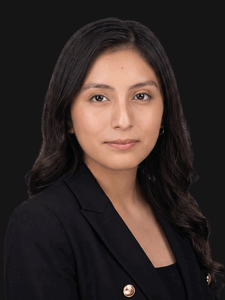 Professional photo of Tania, a young woman with dark hair. She is dressed in business professional clothes.