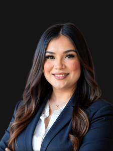 Professional photo of Marina. She is a young woman with dark hair. She is dressed in business professional clothes. 