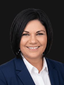 Professional portrait of Holly dressed in business professional attire and smiling.