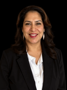 Professional photo of Iris. She is a woman with dark hair. She is dressed in business professional clothes. 