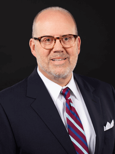 Professional portrait of Rocky dressed in business professional attire and smiling.