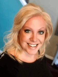 Professional photo of a smiling woman with light blonde hair wearing a black blouse