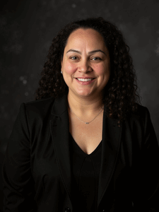 Professional photo of Cassandra. She is wearing business professional clothes. She has dark hair.