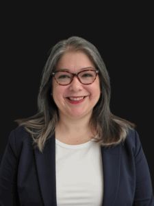 Portrait of Julia dressed in business professional attire and smiling.